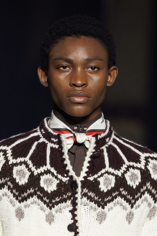 Silhouette WOOYOUNGMI FW26 en manteau d’hiver structuré avec détails faux astrakan, inspirée des voyageurs coréens et de l’élégance historique du froid.