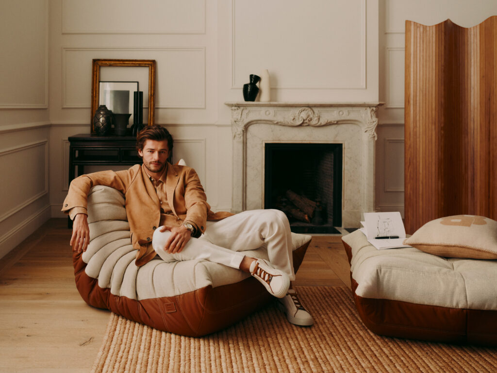 Le danseur Sam Salter sur le Fauteuil Togo édition BOSS x Ligne Roset mêlant cuir et textile dans un intérieur contemporain