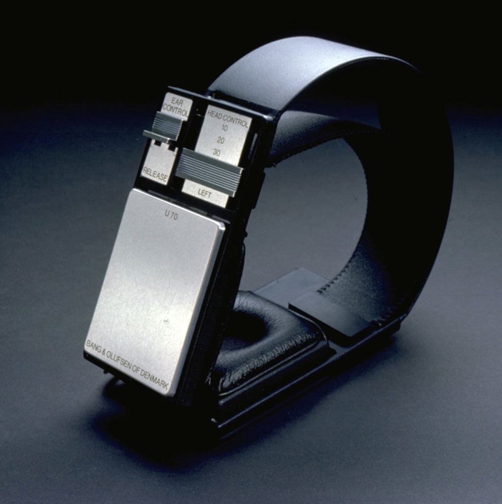 Close-up of a Bang & Olufsen U70 headset with a metal control panel showing ear and head controls.