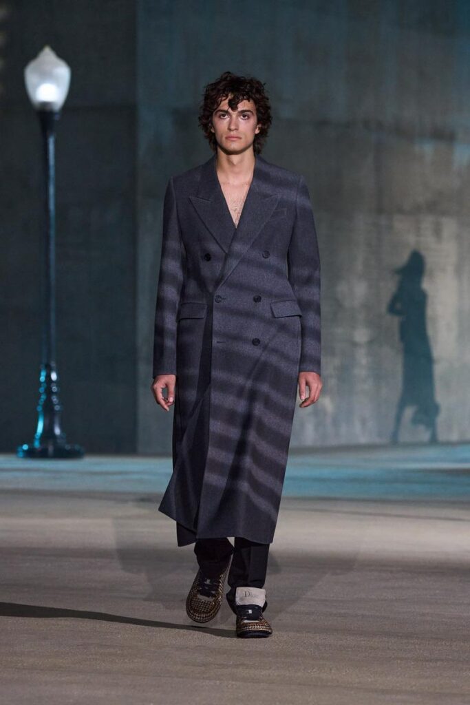 Manteau masculin Dior Cruise 2027 inspiré du film noir, présenté à Los Angeles.