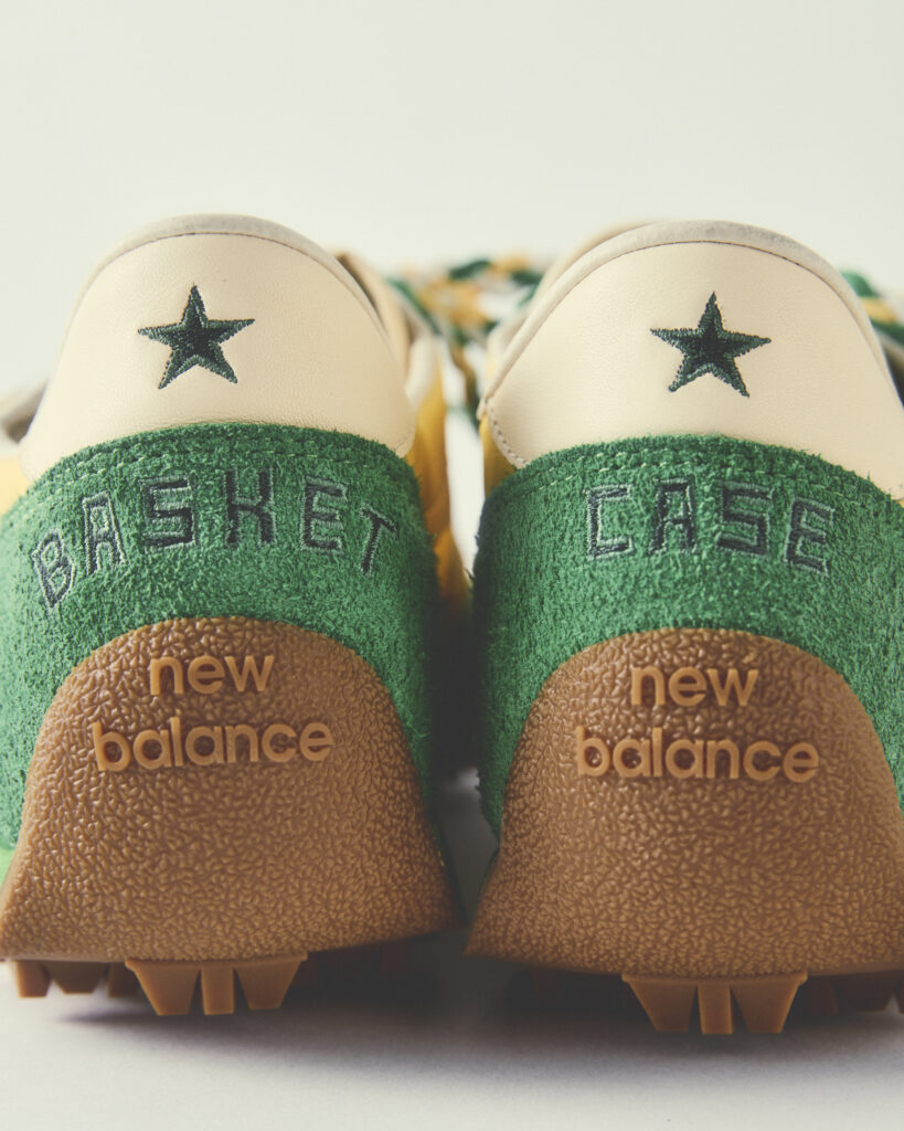 Close-up of two New Balance sneakers: white uppers with green stars, green fabric midsection, and brown textured outsoles viewed from above